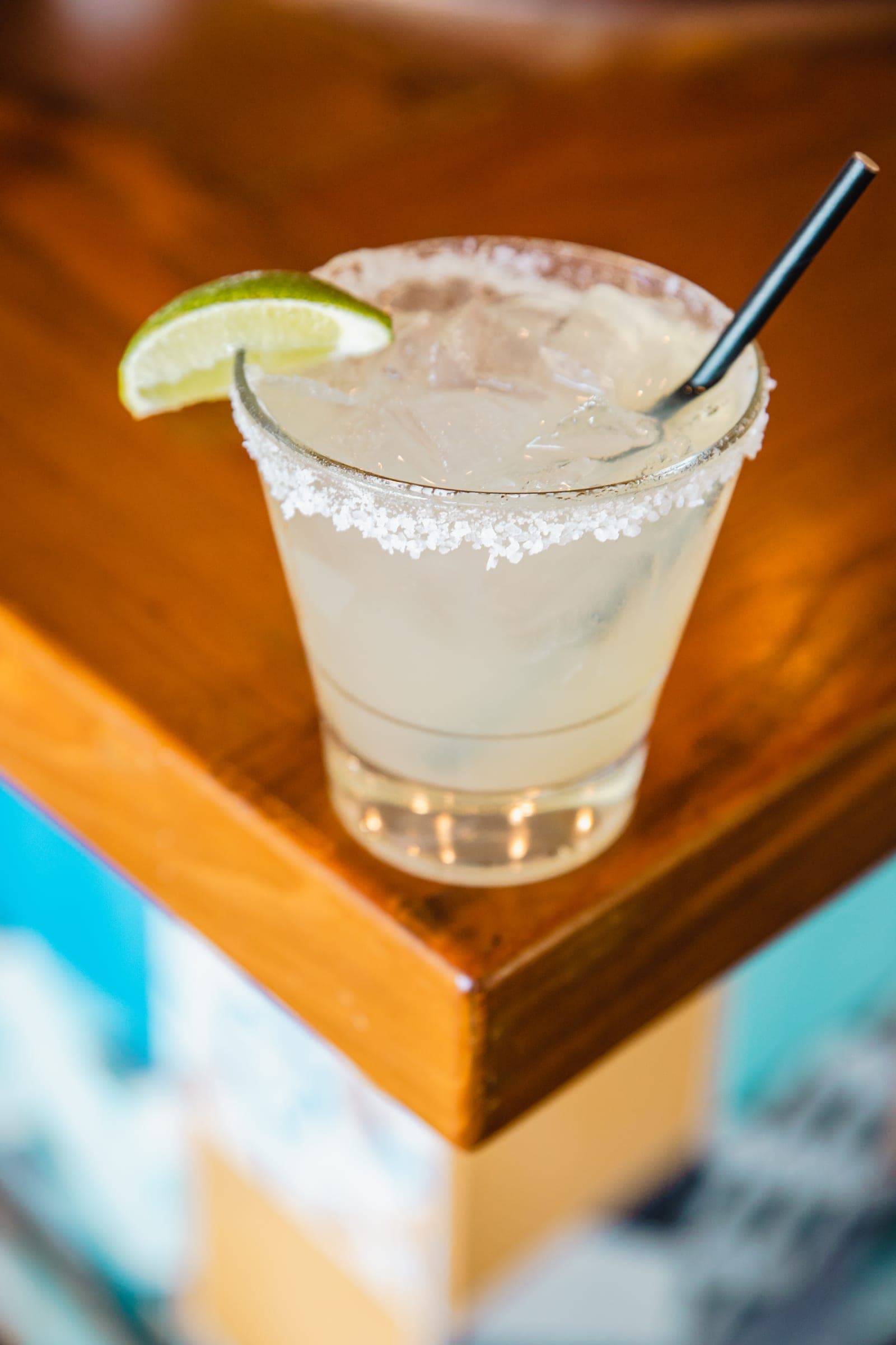 A margarita with a salted rim and a lime wedge