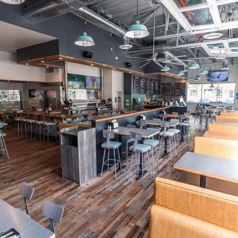 Inside Best Pizza & Brew Carmel Mountain, with bar seating and menu boards above the counter