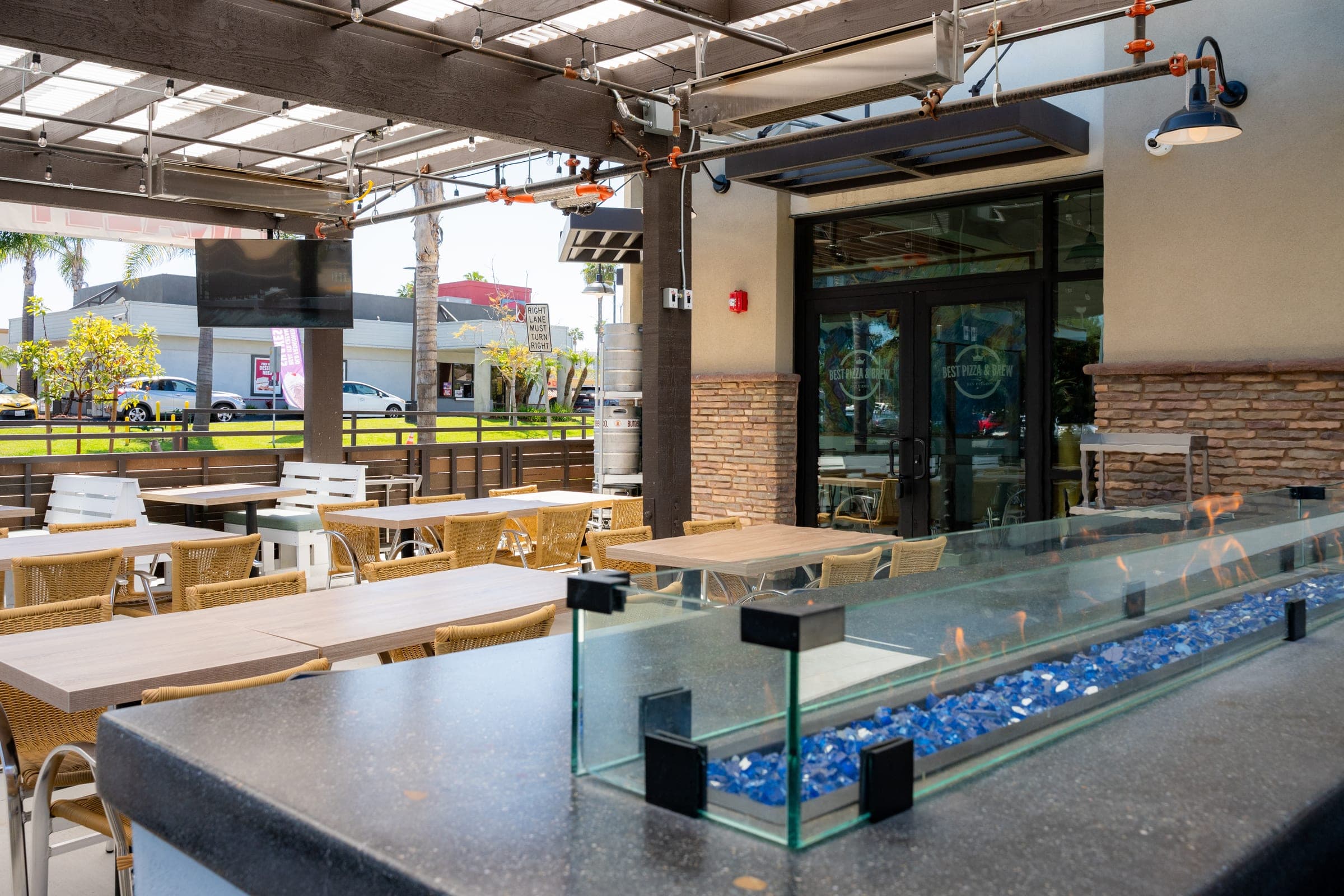 The covered patio at Best Pizza & Brew Clairemont, with communal tables under a slatted roof