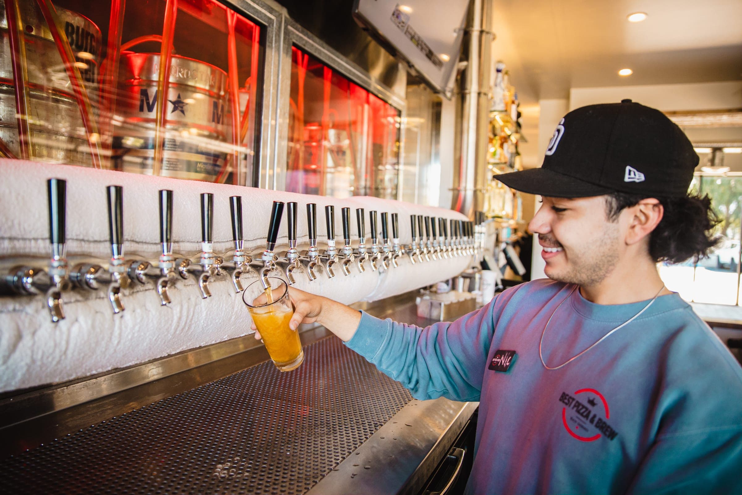 A member of the Vista team pouring a beer at the tap wall