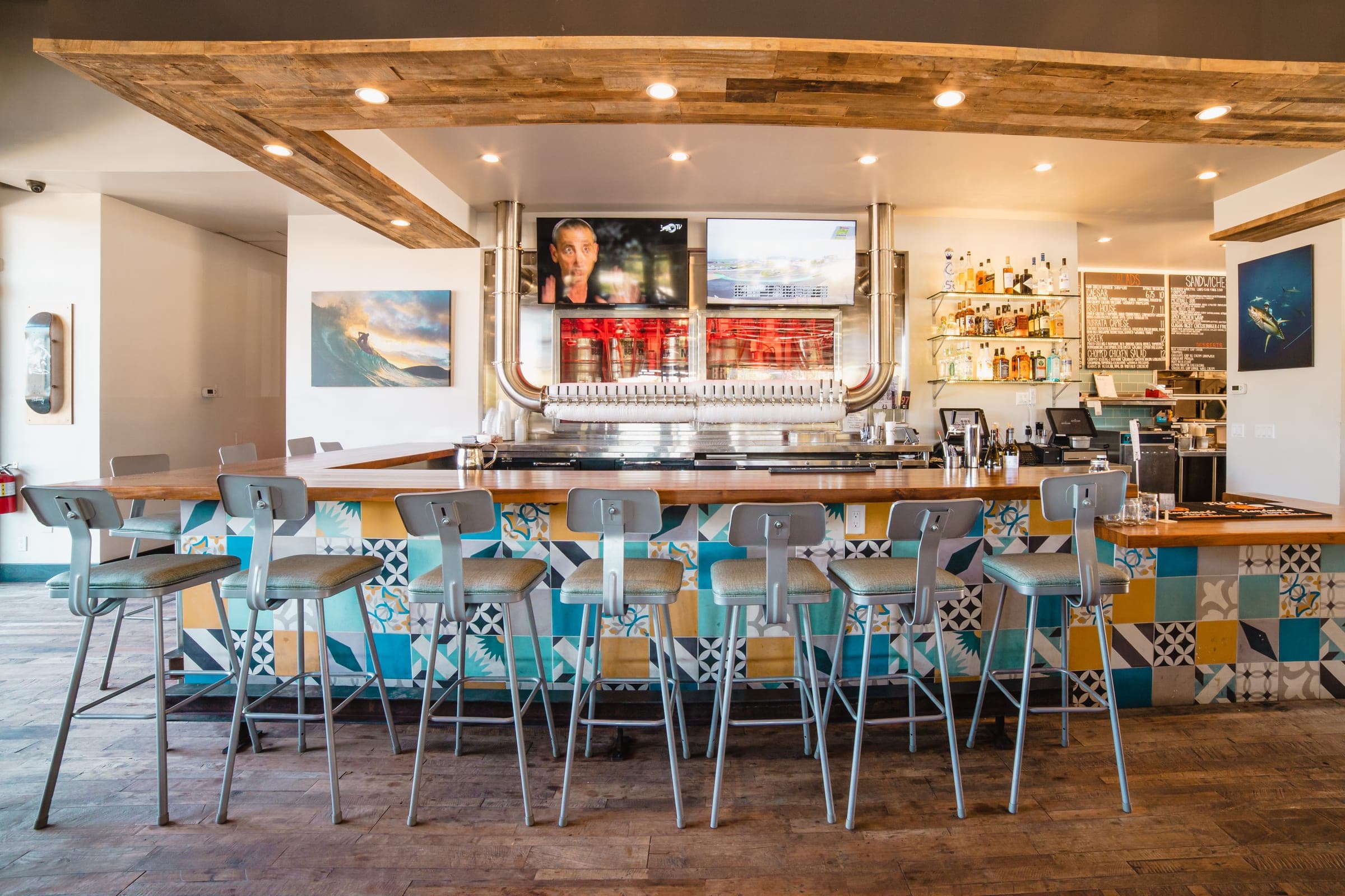 The Vista taproom bar with teal stools and screens above the counter